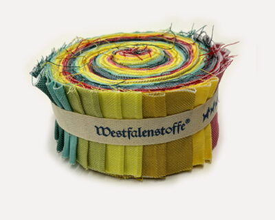 Rolled coil of colorful fabric strips with frayed edges in green, yellow, red, and blue hues.