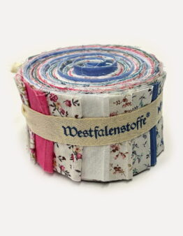 Rolled quilt made of colorful fabric strips, bound with a beige strap.