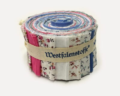 Rolled quilt made of colorful fabric strips, bound with a beige strap.