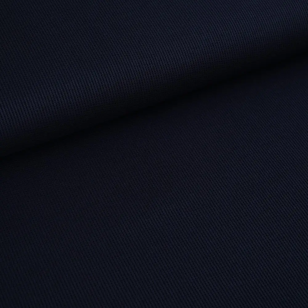 Close-up of dark navy fabric with a diagonal weave and a fold running across the material.