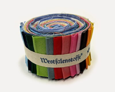 Rolled fabric swatches in rainbow colors bound by a beige strap; frayed edges visible (text on strap reads Westfalenstoff).