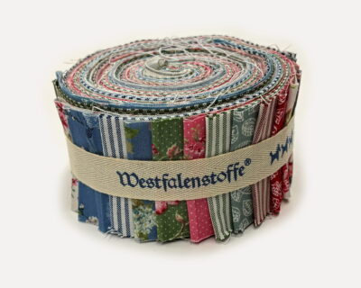 Rolled bundle of colorful fabric strips bound with a beige strap, showing various patterns and stitching details.