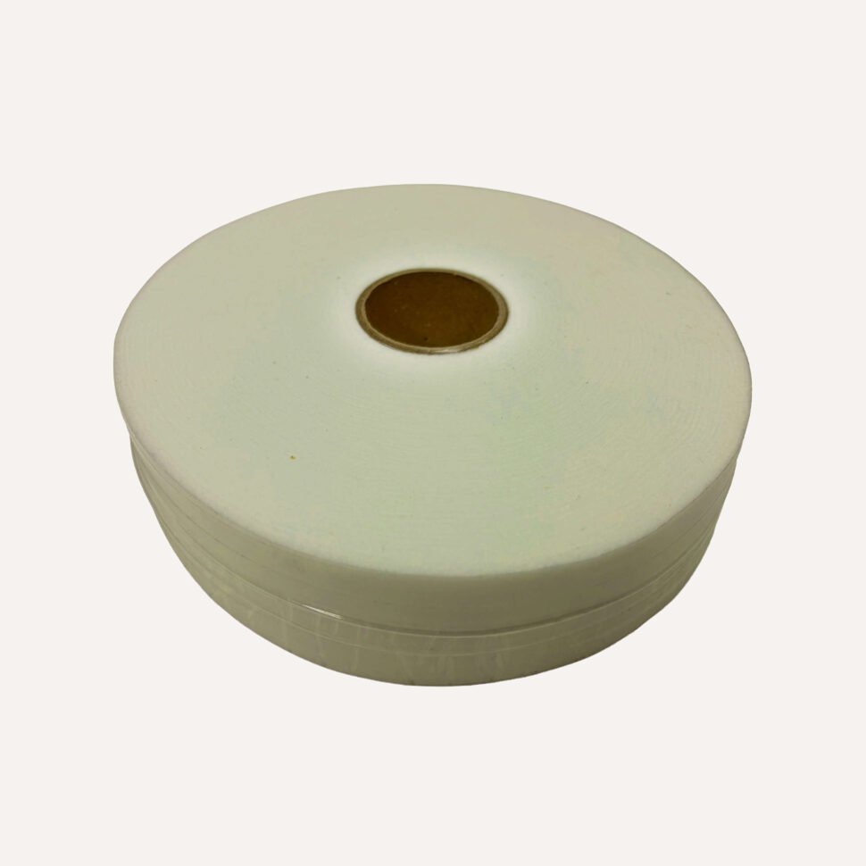 Close-up of a white adhesive tape roll on a pale background, seen from above with a brown center core.
