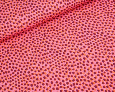 Close-up of bright pink fabric with evenly spaced purple polka dots.
