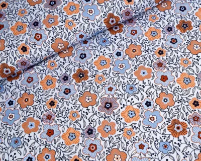 Patterned fabric with orange, blue, and navy flowers and dark vines on a white background (floral print)