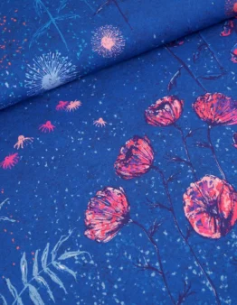 Blue fabric close-up featuring pink blossoms and light blue burst accents on a cobalt background.